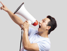 man pointing and shouting down a megaphone